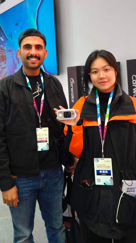 果歐員工手持S0太陽膜測試儀與客戶合影