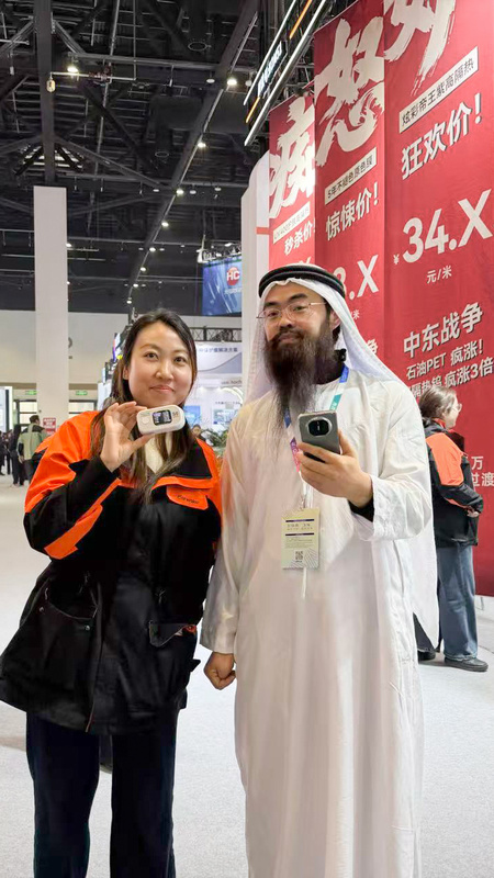 果歐員工手持S0太陽膜測試儀與客戶合影